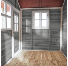 Vnitřní pohled na dětský domeček s dřevěnými stěnami, okny a dřevěnou podlahou