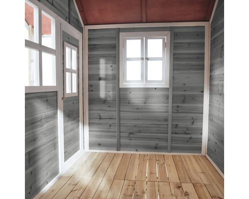 Vnitřní pohled na dětský domeček s dřevěnými stěnami, okny a dřevěnou podlahou