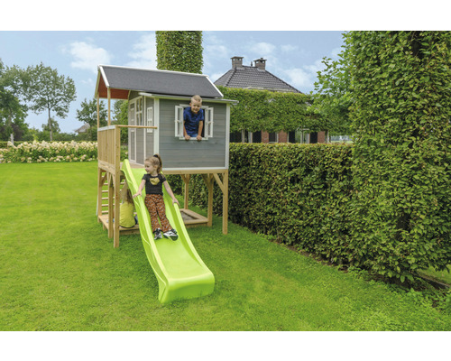 Dětský domek se skluzavkou na zahradě s dětmi