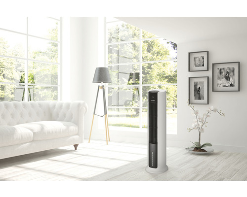 Stojanový ventilátor ve světlém obývacím pokoji s pohovkou a dekoracemi