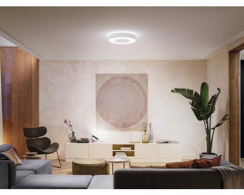 Obývací pokoj s moderním vybavením a kulatým stropním svítidlem