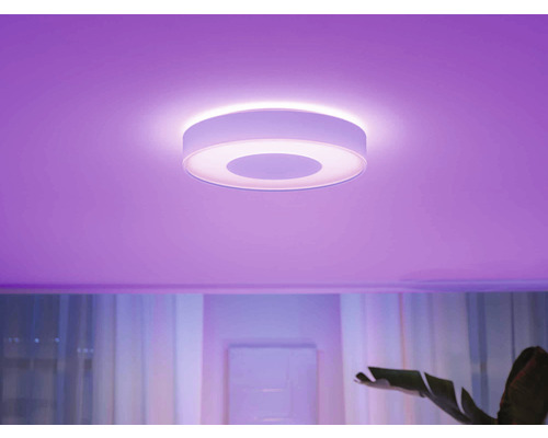 Kulaté stropní svítidlo v místnosti s barevným osvětlením.