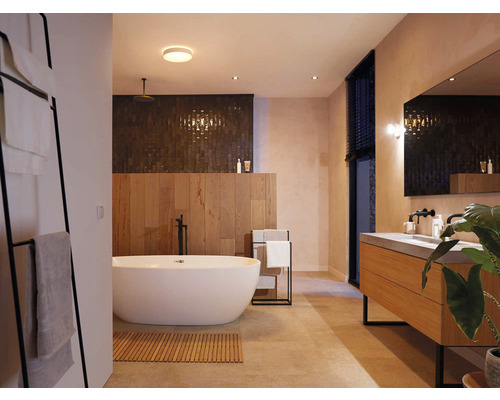 Koupelna s vanou, umyvadlem, zrcadlem a držákem na ručníky pro moderní atmosféru