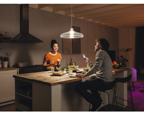 Závěsná lampa nad jídelním stolem v moderní kuchyni se dvěma lidmi