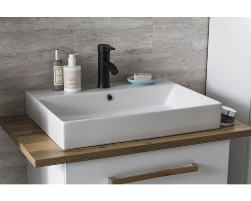 Umyvadlo v koupelně s baterií, mýdlem a kosmetickými produkty