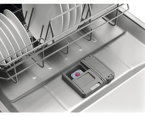 Vnitřní pohled na myčku nádobí s nádobím, košem na nádobí a tabletami do myčky