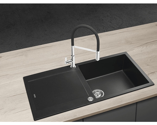 Černý kuchyňský dřez s odkapávací plochou a vodovodní baterií