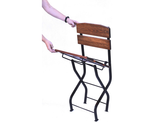 Skládací zahradní židle s dřevěným opěradlem a kovovým rámem při používání