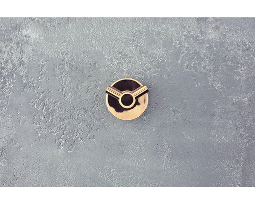 Zlatavý nábytkový knoflík na šedém povrchu