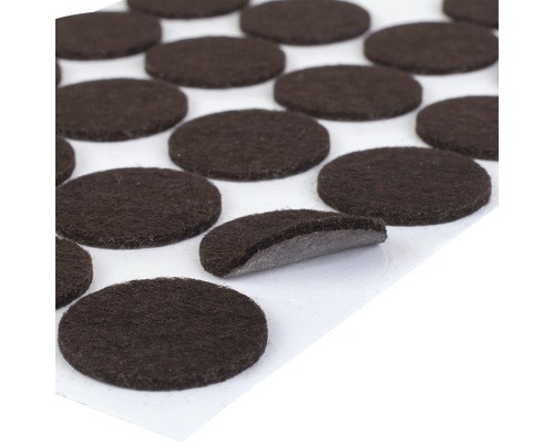 Několik hnědých plstěných nábytkových kluzáků se samolepicí zadní stranou na archu.