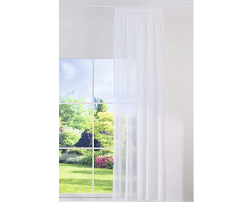 Bílý záclonový závěs před oknem s výhledem do zahrady