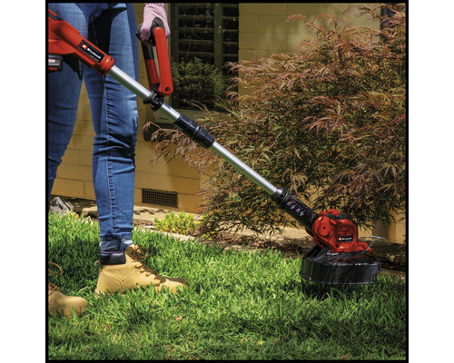 Osoba používá strunovou sekačku značky Einhell na zahradě.