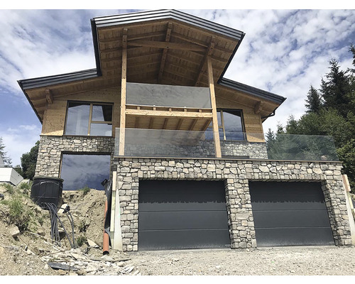 Dům s garáží, kamennou fasádou, dřevěnými prvky a skleněným zábradlím
