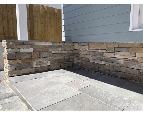 Venkovní prostor s kamennou zdí a dlážděnou podlahou