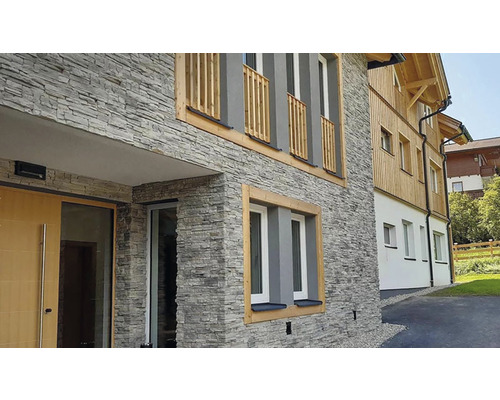 Fasáda domu s obkladem z přírodního kamene a dřevěnými prvky