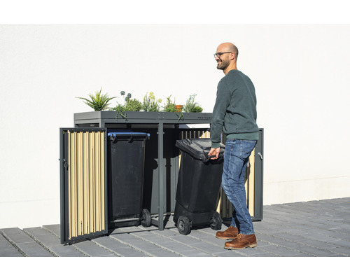Kontejner na popelnice s výsadbou a muž s popelnicí