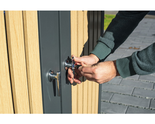 Osoba odemyká dveře zámkem a klíčem