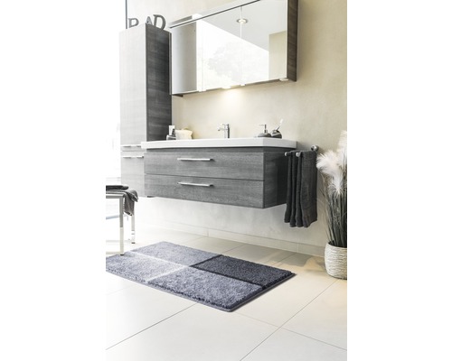 Koupelna s umyvadlovou skříňkou, zrcadlovou skříňkou, ručníkem a koupelnovým kobercem