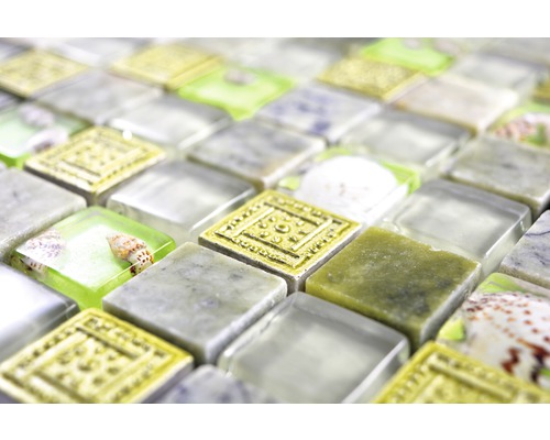 Detailní záběr mozaikových dlaždic s prvky ze skla, kamene a mušlí