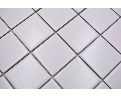 Detailní záběr bílé mozaikové dlaždice s čtvercovými prvky