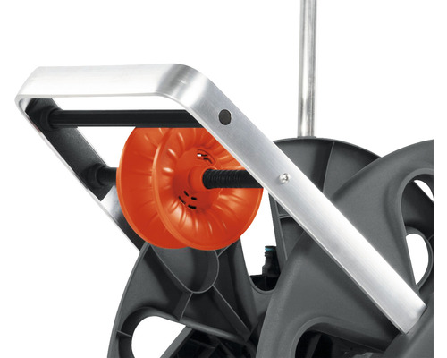 Detailní pohled na naviják zahradní hadice s oranžovým bubnem na hadici