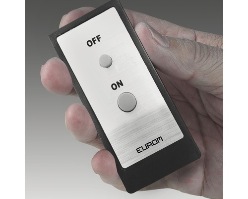 Ruka drží dálkové ovládání s tlačítkem zapnutí a vypnutí.