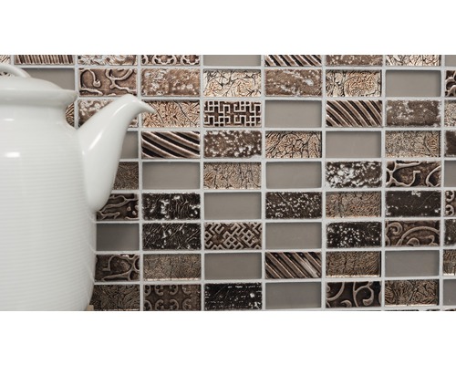 Mozaikové dlaždice s ornamenty a bílá konvice na čaj