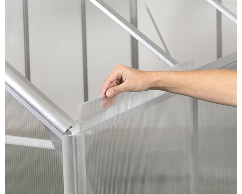 Detailní pohled na instalaci stěnových prvků z plastu ve skleníku