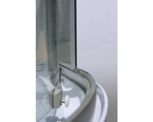 Detail sprchového koutu se skleněnými stěnami a rolovacím mechanismem