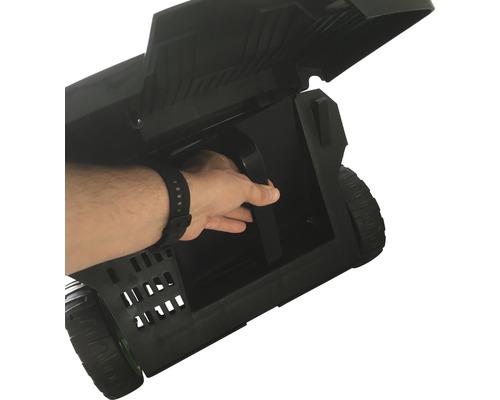 Černý přepravní box s kolečky a otevřeným víkem, ruka sahá po rukojeti