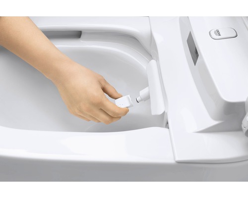 Osoba vyměňuje trysku sprchového záchodu.