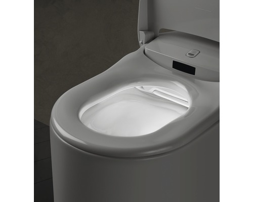 Detailní záběr toalety s otevřeným víkem a vnitřním osvětlením.