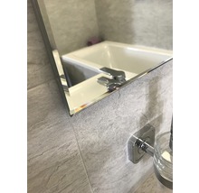 Detail koupelnového zrcadla s umyvadlem a baterií