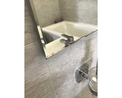 Detail koupelnového zrcadla s umyvadlem a baterií