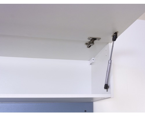 Vnitřní pohled na bílou kuchyňskou skříňku s panty a plynovou pružinou