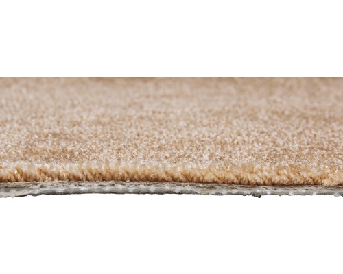 Detailní pohled na béžový koberec, ukazující texturu a vlas.