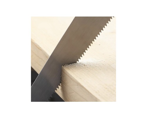 Ruční pila při řezání kusu dřeva