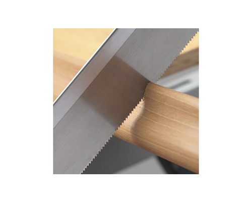 Ruční pila řeže kus dřeva.