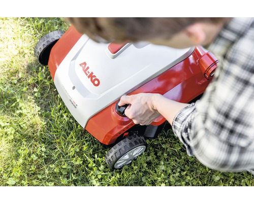 Osoba startuje sekačku na trávu značky Al-ko na trávníku.