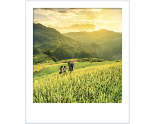 Zarámovaný obraz venkovské scény s lidmi na poli před kopcovitou krajinou