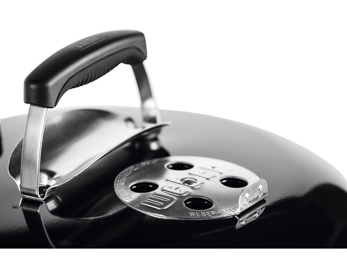 Detailní pohled na gril Weber s kulatým grilem, rukojetí víka a ventilačním jezdcem