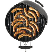 Kulatý gril s roštem a grilovanými klobásami.