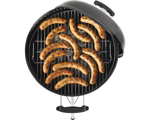 Kulatý gril s roštem a grilovanými klobásami.