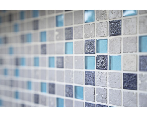 Detailní záběr stěny s čtvercovými mozaikovými dlaždicemi ve vzhledu kamene, skla a s ornamenty