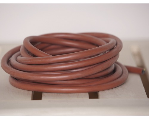 Stočená topná hadice na dřevěném povrchu