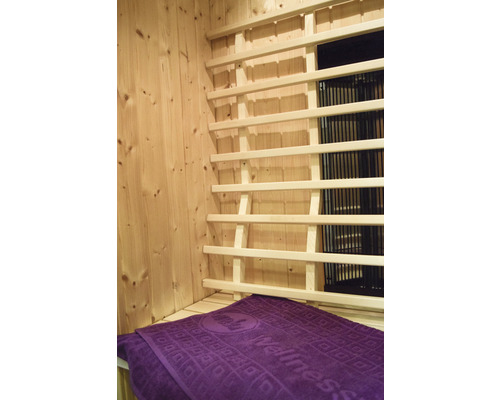 Interiér sauny s dřevěným obložením, infračerveným zářičem a ručníkem