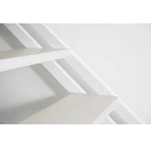 Detail bílého dřevěného schodiště před bílou zdí