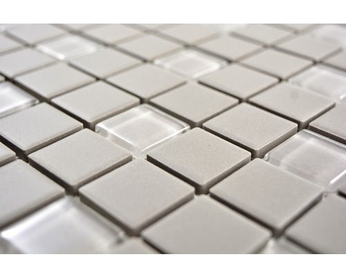 Detailní záběr mozaikových dlaždic se čtvercovými šedými kameny a průhlednými skleněnými prvky