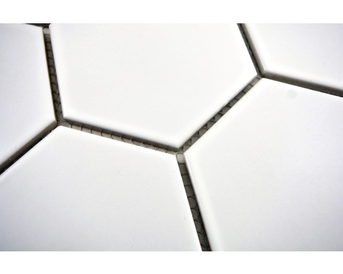 Detail šestiúhelníkových bílých dlaždic se spárami