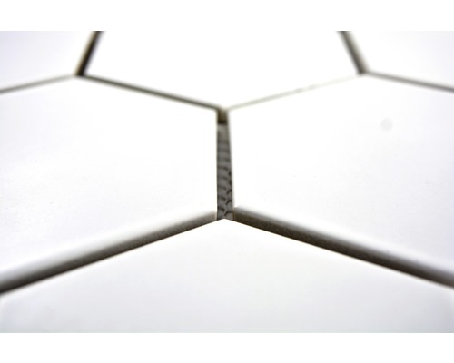 Detail bílých šestihranných dlaždic se spárami